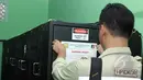 Petugas Tipidkor memasang segel penyitaan di sejumlah sekolah di kawasan Kebon Jeruk, Jakarta, Kamis (21/5). Petugas melakukan penyitaan barang bukti UPS anggaran 2014 atas nama tersangka Alex Usman. (Liputan6.com/Helmi Afandi)