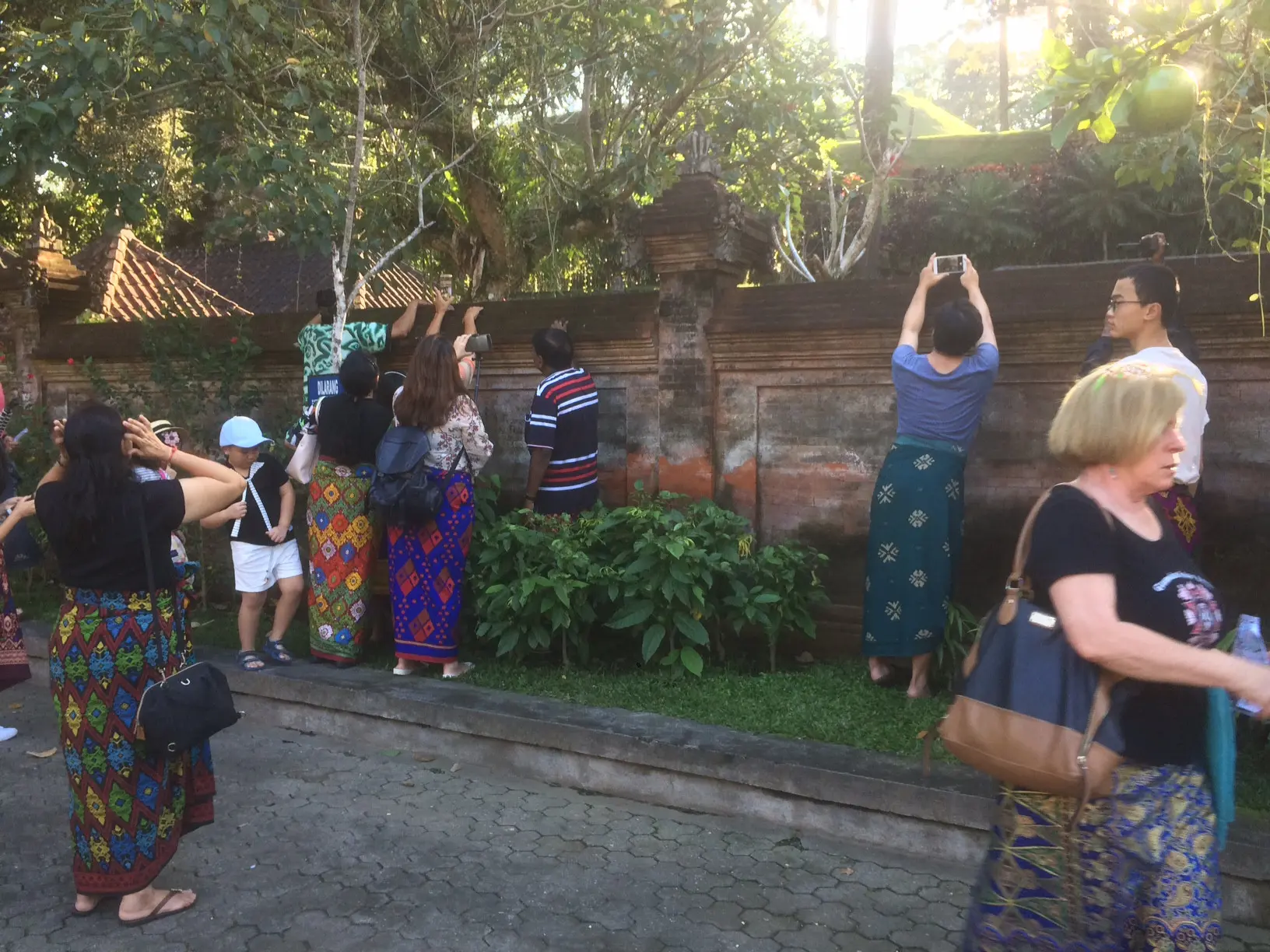 Aksi pengunjung saat berusaha memfoto kunjungan Barack Obama dan keluarga ke Pura Tirta Empul, Bali (27/6/2017) (Andreas Gerry Tuwo/Liputan6.com)