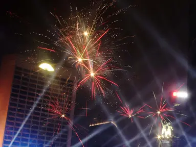 Nyala kembang api memeriahkan suasana malam pergantian tahun di kawasan Bundaran Hotel Indonesia, Jakarta, Selasa (31/12/2019). Ribuan masyarakat melewati malam pergantian tahun 2019 menuju 2020 dengan menyalakan kembang api dan menikmati panggung hiburan. (Liputan6.com/Angga Yuniar)