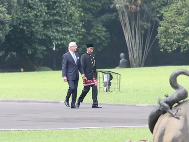 Presiden Joko Widodo berjalan mendampingi Raja Carl XVI Gustaf melintasi taman di halaman belakang Istana Bogor, Jawa Barat, Senin (22/5). (Liputan6.com/Angga Yuniar)