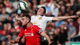 Gelandang Liverpool, Jordan Henderson berebut bola udara dengan pemain Manchester United Phil Jones saat Laga Liga Premier Inggris di Anfield Stadium, Inggris, Minggu (22/3/2015 ). Manchester United menang 2-1 atas Liverpool. (Reuters/Carl Recine)