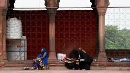 Sejumlah wanita Muslim duduk di masjid Jama  di kawasan lama New Delhi, India (30/7/2019). Masjid ini selesai pada tahun 1656 M dan merupakan yang terbesar dan terkenal di India. (AFP Photo/Money Sharma)