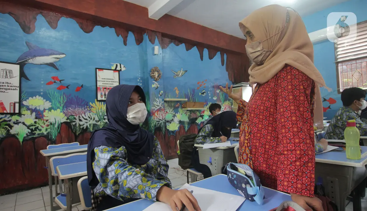 Guru saat mengajar di SMP Negeri 1 Kota Tangerang, Kamis (12/5/2022). Sekolah di Kota Tangerang mulai menggelar pembelajaran tatap muka (PTM) setelah libur lebaran 2022. (Liputan6.com/Angga Yuniar)