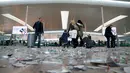 Penumpang menarik koper melewati sampah yang berserakan di Bandara Barcelona, Spanyol, Kamis (1/12). Sampah-sampah yang berserakan tersebut sebagai bentuk aksi protes para petugas kebersihan untuk pemotongan anggaran 1,3 juta Euro. (REUTERS/Albert Gea)