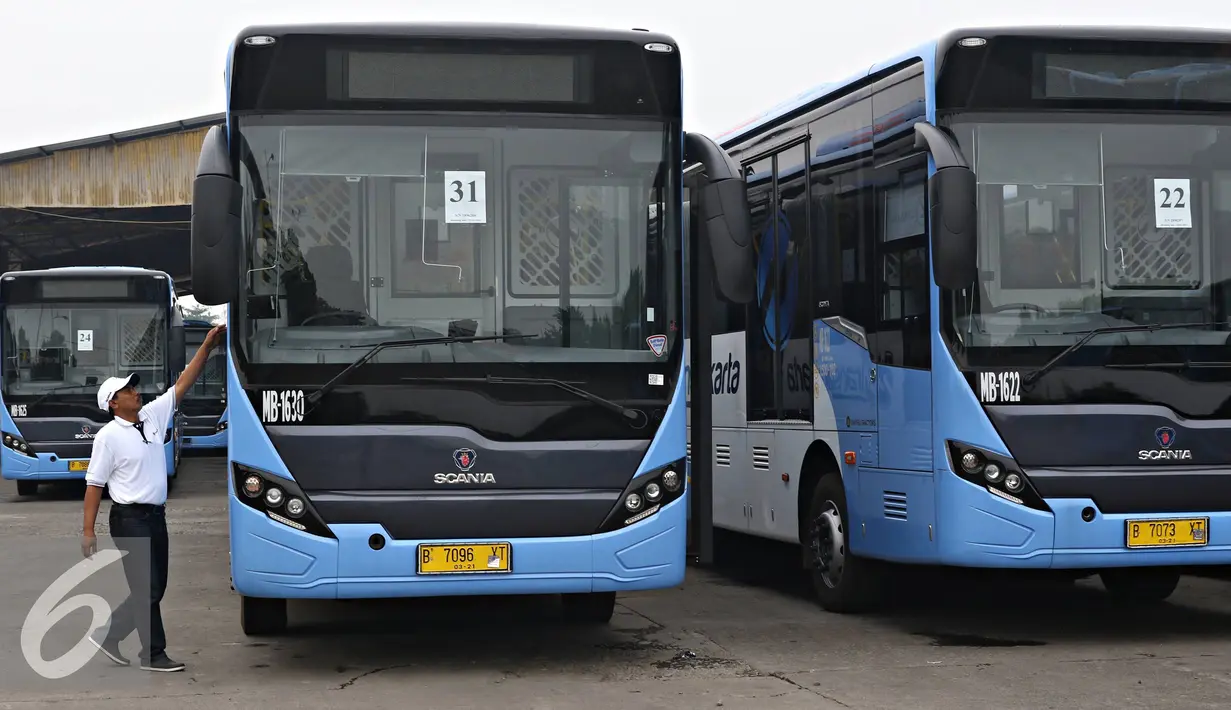 Petugas memeriksa bagian pintu bus gandeng yang siap dioperasikan di Pul PT Mayasari Bakti, Klender, Jakarta Timur, Selasa (26/4). PT Mayasari Bakti mendukung PT Transjakarta dalam mengelola transportasi umum di ibukota.( Liputan6.com/Immanuel Antonius)