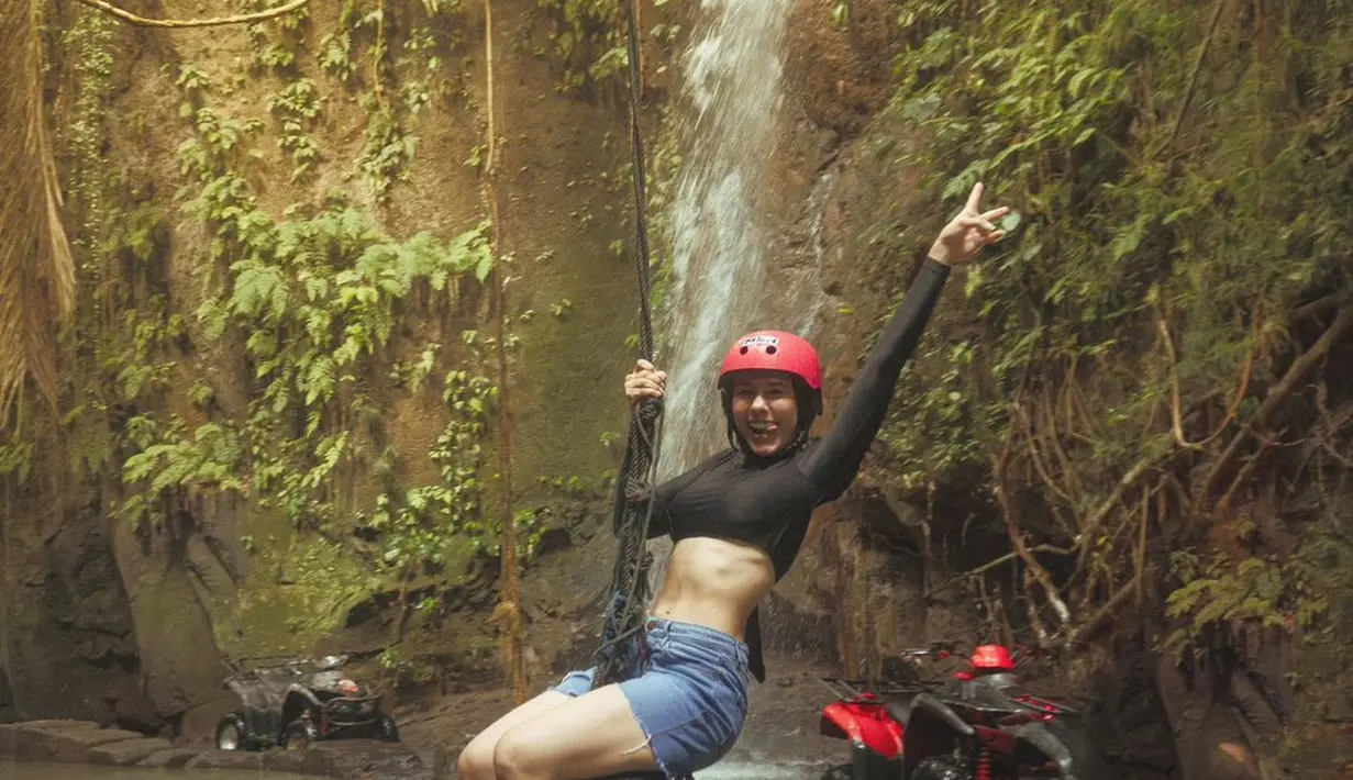 Serunya Wulan Guritno sedang bermain di alam. Ia mengenakan cropped top hitam lengan panjang dipadu dengan denim pants pendek. [Foto: Instagram/wulanguritno]