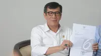 Menkumham Yasonna Laoly menunjukkan surat keputusan saat jumpa pers di Kemenkumham, Jakarta, Selasa (10/3/2015). Kementerian Hukum dan HAM mengesahkan DPP Partai Golkar hasil Munas Ancol kubu Agung Laksono. (Liputan6.com/Herman Zakharia)