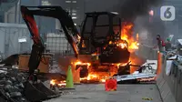 Massa membakar backhoe di Jalan MH. Thamrin, Jakarta, Kamis (8/10/2020). Aksi anarkis massa dilakukan setelah bentrok dengan petugas kepolisian di kawasan Patung Kuda, Jakarta.(merdeka.com/Arie Basuki)