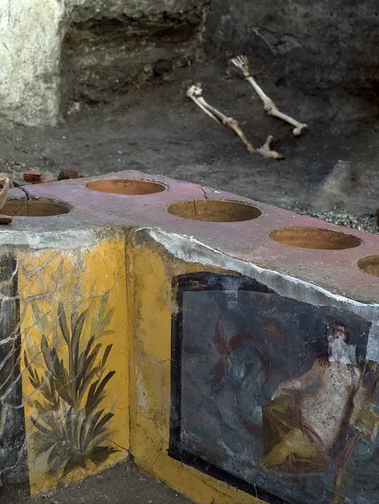Gambar yang dirilis pada 26 Desember 2020 menunjukkan termopolium, semacam konter "makanan cepat saji" pinggiran jalan (street food) pada era Romawi kuno, di Pompeii. Bagian depan meja toko dihias oleh lukisan dinding berwarna cerah. (Luigi Spina/Parco Archeologico di Pompei via AP)