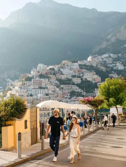 Jalan-jalan bareng sang kekasih di Positano, Amalfi Coast, Italy, Wulan Guritno tampil simple mengenakan silk dress putih dipadukan cardigan pink.  @wulanguritno.