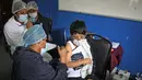 Seorang anak menerima dosis vaksin covid-19 Sinopharm di La Paz, Bolivia, Kamis (9/12/2021). Presiden Bolivia Luis Arce mengizinkan vaksinasi anak berusia antara 5 hingga 11 tahun untuk menekan laju peningkatan infeksi COVID-19 di negara itu. (LUIS GANDARILLAS / AFP)