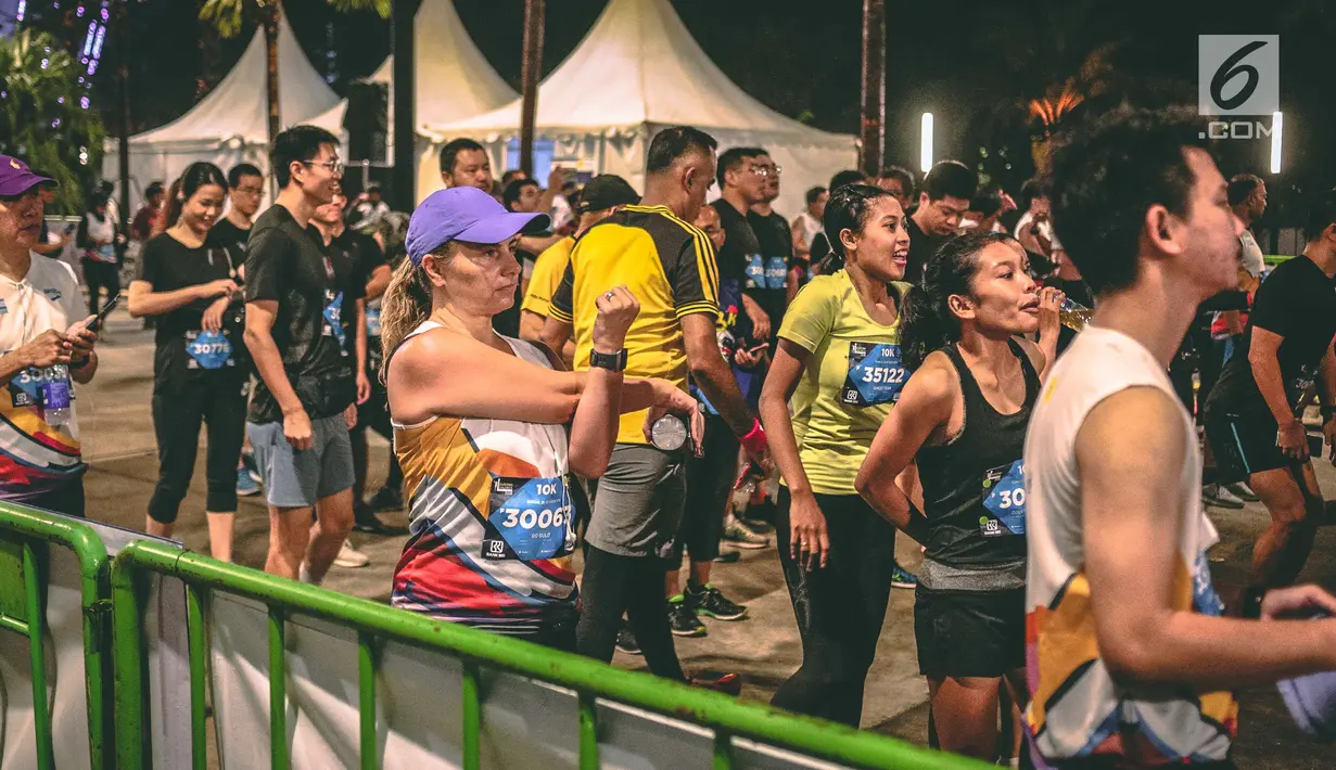 Peserta pemanasan sebelum mengikuti Jakarta Marathon 2018 di Gelora Bung Karno, Jakarta, Minggu (28/10). Sebanyak 12.500 pelari meramaikan Jakarta Marathon 2018, Memasuki tahun keenam, Jakarta Marathon yang di sponsori PLN. (Liputan6.com/Faizal Fanani)