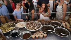 Sejumlah orang melihat jajanan yang berbahan dasar utama dari serangga, Sydney, Australia, Sabtu (28/4). Kecoa panggang, semut rasa madu, larva berlapis coklat dsb tersedia di kios tersebut. (AFP FOTO / ANDREW MURRAY )