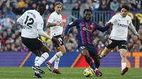 Gelandang Barcelona, Franck Kessie menggiring bola saat bertanding melawan Valencia selama pertandingan lanjutan La Liga Spanyol di stadion Camp Nou, Spanyol, Minggu (5/3/2023). Barcelona menang tipis atas Valencia dengan skor 1-0. (AP Photo/Joan Monfort)