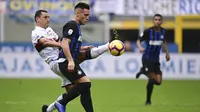 Striker Inter Milan, Lautaro Martinez, berebut bola dengan gelandang Genoa, Romulo, pada laga Serie A Italia di Stadion San Siro, Milan, Sabtu (3/11). Inter menang 5-0 atas Cagliari. (AFP/Miguel Medina)