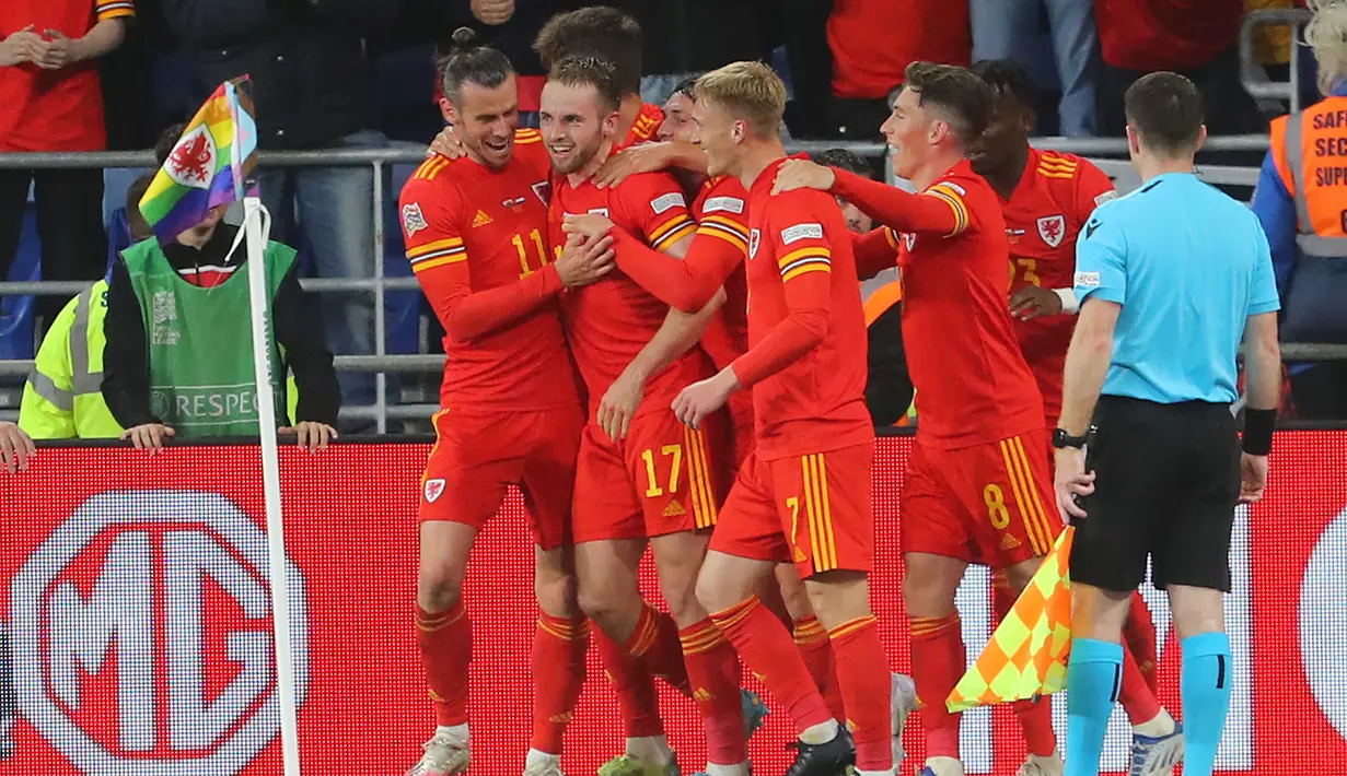 Bek Wales, Rhys Norrington-Davies (tengah) merayakan dengan rekan setimnya setelah mencetak gol ke gawang Belanda selama pertandingan grup A4 UEFA Nations League di stadion Cardiff City di Cardiff, Wales selatan, Kamis (9/6/2022). Belanda menang tipis atas Wales 2-1. (AFP/Geoff Caddick)