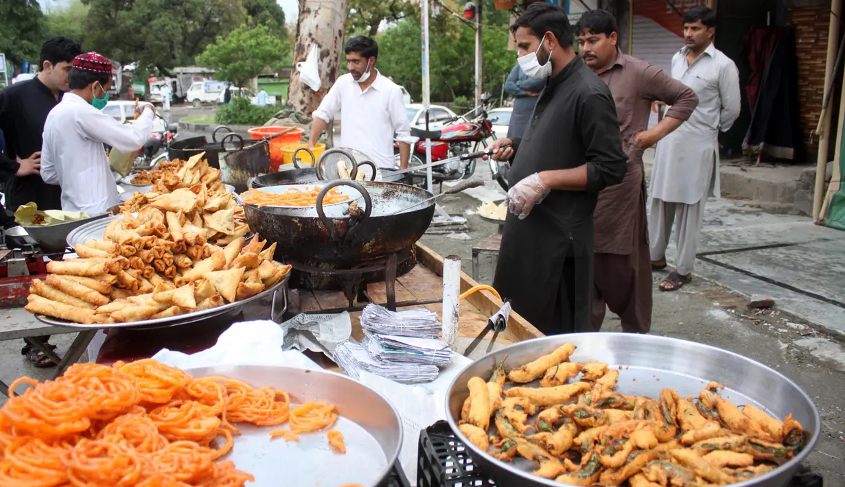 Warga membeli camilan di penjaja makanan untuk berbuka puasa pada hari pertama bulan suci Ramadan di Rawalpindi, Provinsi Punjab, Pakistan, Sabtu (25/4/2020). (Xinhua/Ahmad Kamal)