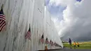 File foto 31 Mei 2018 ini, pengunjung di Peringatan Nasional Penerbangan 93 berhenti di Wall of Names untuk menghormati 40 penumpang dan anggota awak United Flight 93 yang tewas ketika jet yang dibajak itu jatuh di lokasi tersebut selama teroris 9/11. (AP Photo/Gene J. Puskar)