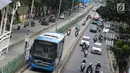 Pengendara motor melaju di belakang bus Transjakarta di kawasan Pasar Rumput, Jakarta, Rabu (20/2). Sekitar 510 CCTV akan dipasang di 225 halte Transjakarta di Ibu Kota untuk menerapkan tilang online atau E-Tilang. (Liputan6.com/Immanuel Antonius)