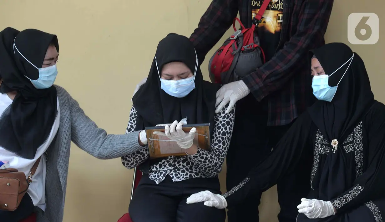 Tangis keluarga korban kecelakaan Sriwijaya Air SJ 182 saat serah terima jenazah di RS Polri, Jakarta, Kamis (14/1/2021). Jenazah atas nama Okky Bisma menjadi korban kecelakaan Sriwijaya Air SJ 182 pertama yang berhasil teridentifikasi oleh tim DVI. (merdeka.com/Imam Buhori)