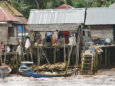 Warga mencuci pakaian di bantaran Sungai Musi, Sumatera Selatan, (26/3). Pemerintah Kota Palembang fokus menata kawasan pinggiran Sungai Musi untuk mengejar target bebas pemukiman kumuh pada 2019. (Liputan6.com/Gempur M Surya)