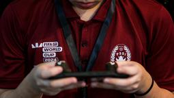 Seorang peserta kategoir mobile berkompetisi dalam seleksi nasional atau Indonesia National Qualifier FIFAe World Cup 2024 yang berlangsung di Point Arena, Jakarta Selatan, Sabtu (02/11/2024). (Bola.com/Bagaskara Lazuardi)