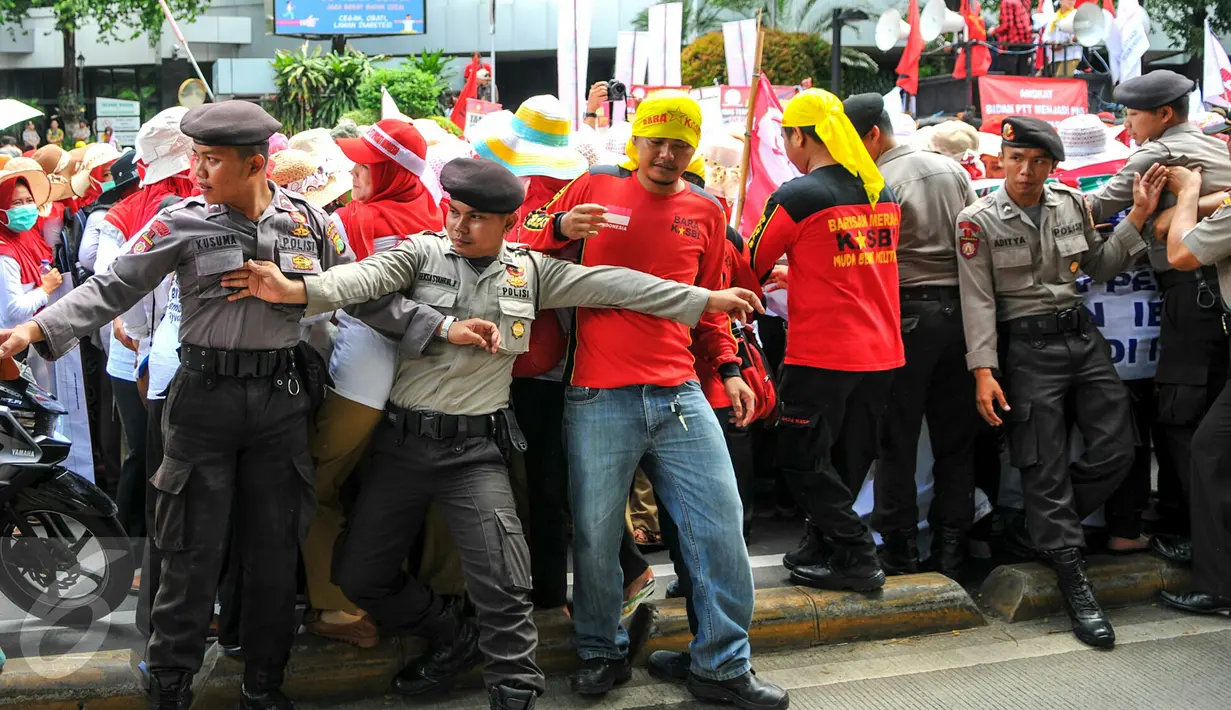 Personel kepolisian berusaha menahan para bidan desa yang berupaya menutup akses jalan saat demonstrasi di depan gedung Kemenkes, Jakarta, Rabu (4/5). Para bidan menuntut diangkat menjadi pegawai tetap tanpa syarat.  (Liputan6.com/Yoppy Renato)