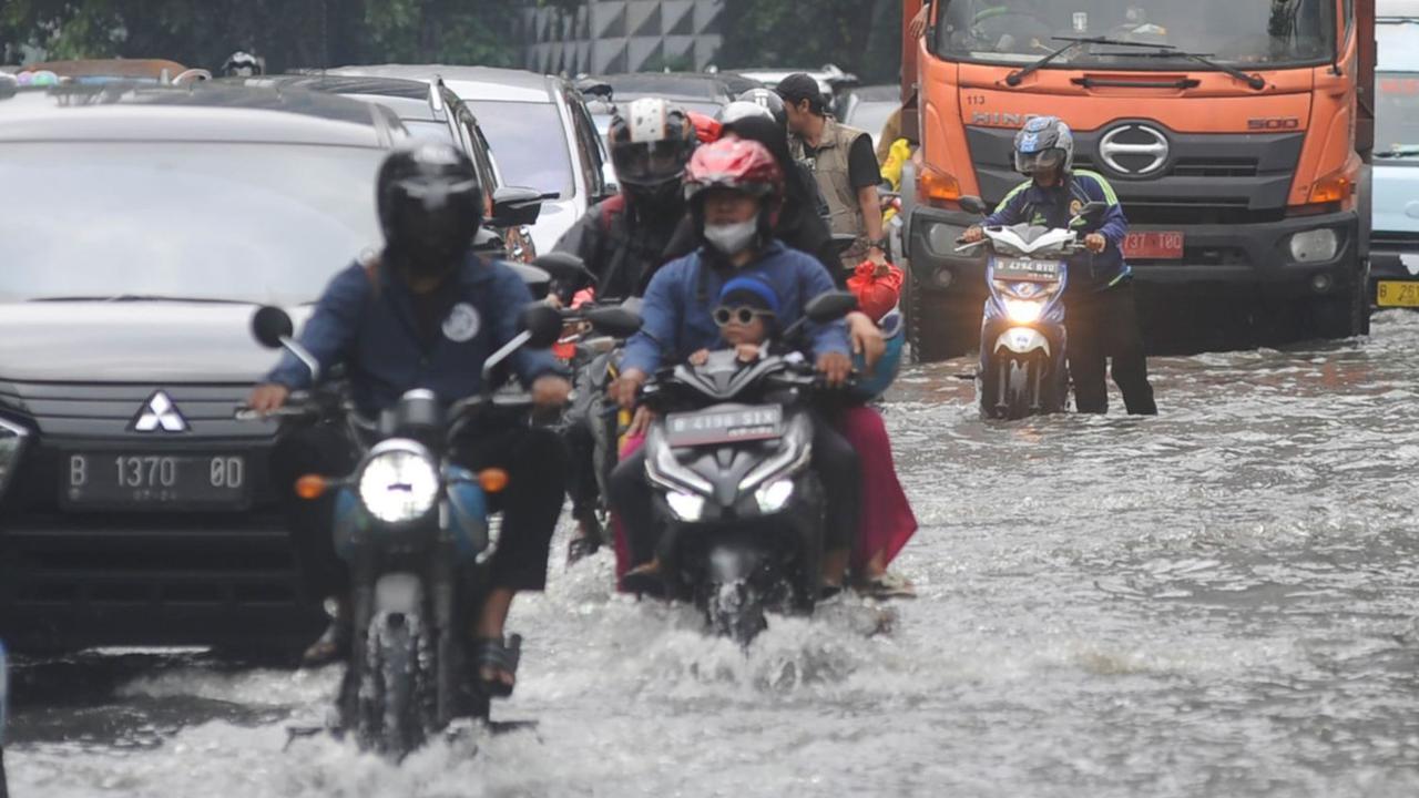 Banjir yang terjadi akibat luapan kali Sekretaris ini telah menyebabkan kemacetan lalu lintas. <br><br>Kendaraan terpaksa memperlambat lajunya ketika melintasi jalan tersebut. Foto: merdeka.com / Arie Basuki