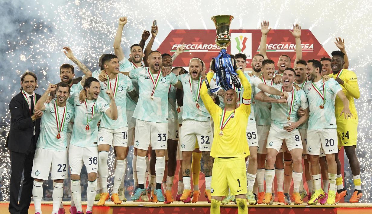 Kiper Inter Milan, Samir Handanovic, mengangkat tofi juara setelah memenangkan final Coppa Italia melawan Fiorentina di Stadion Olimpico, Kamis (25/5/2023). Inter berhasil meraih trofi ke-9 di Coppa Italia. (AFP/IsabellaBonotto)