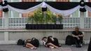 Dua orang wanita tidur saat menunggu pemakaman mendiang Raja Thailand Bhumibol Adulyadej di Bangkok (25/10). Upacara pemakaman Raja Bhumibol Adulyadej ini akan berlangsung selama lima hari. (AFP Photo/Roberto Schmidt)