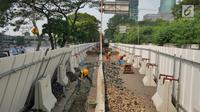 Pekerja mengerjakan proyek pembangunan jalur kereta Light Rail Transit (LRT) di Jalan Setiabudi Tengah, Jakarta, Senin (17/6/2019). Jalan Setiabudi Tengah ditutup untuk memberi ruang terkait pengerjaan konstruksi jalur LRT. (Liputan6.com/Herman Zakharia)