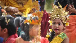 Ekspresi seorang murid TK Sekolah Alternatif untuk Anak Jalanan (SAAJA) saat mengenakan pakaian adat di kawasan Kuningan, Jakarta, Selasa (21/4/2015). Kegiatan itu dalam rangka Hari Kartini yang diperingati setiap 21 April. (Liputan6.com/Faizal Fanani)