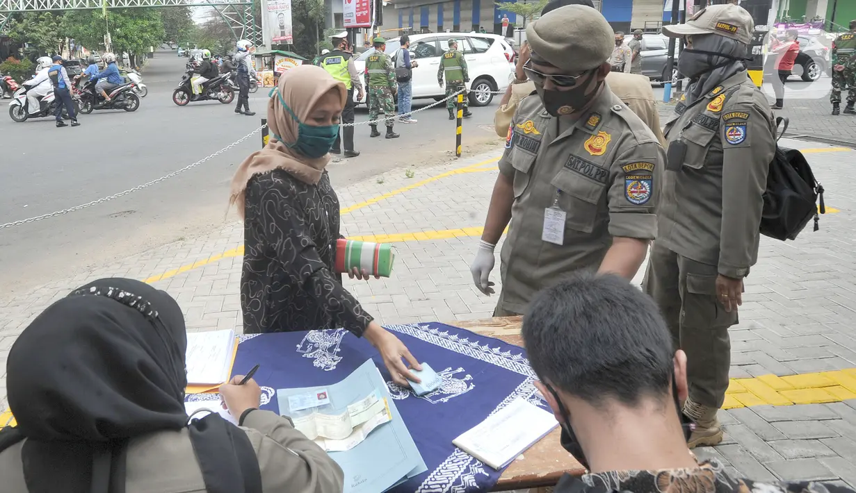 Warga pelanggar PSBB dihukum membayar denda saat razia di Jalan Raya Cinere, Depok, Jawa Barat, Senin (24/8/2020). Pelanggar PSBB Kota Depok yang saat ini kembali menjadi zona merah mendapat hukuman sosial atau denda. (merdeka.com/Arie Basuki)