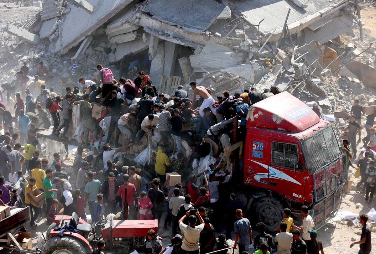 FOTO: Di Tengah Gencatan Senjata, Warga Gaza Berebut Bantuan Bahan Makanan untuk Bertahan Hidup
