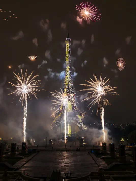 Kembang api menerangi Menara Eiffel pada perayaan Hari Bastille di Paris, Prancis, Rabu (14/7/2021). Prancis telah merayakan hari libur nasionalnya dengan ribuan tentara berbaris dalam parade Paris dan pesta tradisional di seluruh negeri. (AP Photo/Lewis Joly)