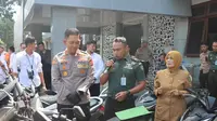 Kapolres Garut AKBP Rio Wahyu Anggoro, mendampingi seorang petugas militer dalam rilis kasus pencurian kendaraan bermotor di Mapolres Garut, Senin (12/6/2023). (Liputan6.com/Jayadi Supriadin)