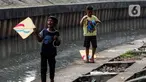 Anak-anak bermain layang-layang di pinggir kali Jalan Inspeksi Jakarta Barat, Rabu (12/7/2023). Meski berbahaya, mereka tetap menikmati bermain di pinggir kali tersebut. (Liputan6.com/Johan Tallo)
