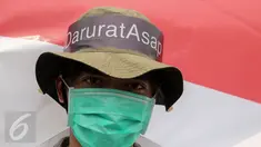 Massa dari Aksi Cepat Tanggap (ACT) melakukan aksi menolak asap dengan menggunakan masker di Patung Kuda, Jakarta, Senin (26/10). Aksi itu menuntut elemen masyarakat agar terlibat langsung dalam upaya penuntasan masalah asap. (Liputan6.com/Faizal Fanani)