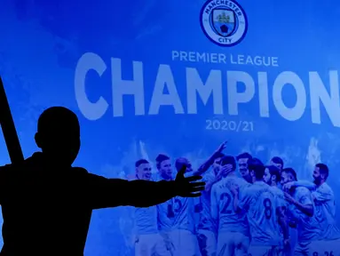 Seorang fans Manchester City merayakan keberhasilan timnya memastikan merebut gelar juara Liga Inggris 2020/2021 di luar Etihad Stadium, Selasa (11/5/20221) sesaat setelah kekalahan pesaing terdekat Manchester United 1-2 oleh Leicester City di Old Trafford. (AP/Jon Super)