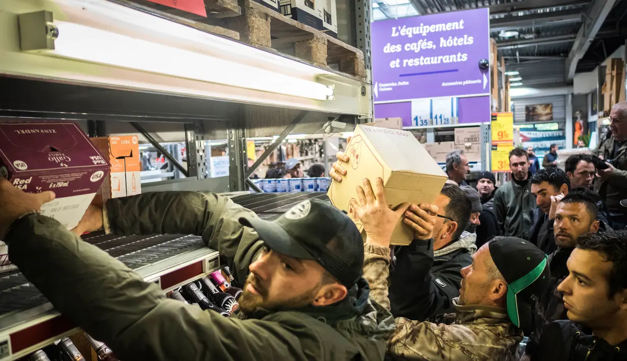 Sejumlah orang merangsek masuk ke hypermarket dan mengambil minuman anggur di Nimes, Perancis, Kamis (20/4). Mereka marah karena persaingan harga anggur yang dianggap tidak adil. (AP Photo / Arnold Jerocki)