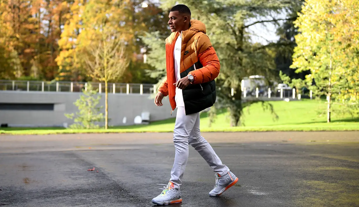 Penyerang Kylian Mbappe tiba di tempat pelatihan tim nasional Prancis Prancis di Clairefontaine en Yvelines (11/11/2019). Kylian Mbappe tampil keren dengan kaos putih dan jaket orange. (AFP Photo/Franck Fife)