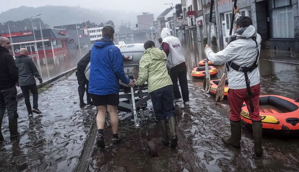 Warga menggunakan rakit karet untuk mengungsi setelah Sungai Meuse jebol saat banjir besar di Liege, Belgia, Kamis (15/7/2021). Banjir melanda sejumlah negara di kawasan Eropa barat. Selain Belanda dan Jerman, banjir juga menerjang Belgia. (AP Photo/Valentin Bianchi)