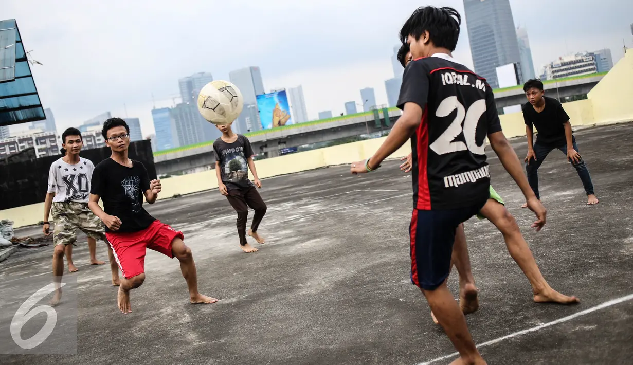 Sejumlah remaja bermain futsal di atas gedung di Pasar Mampang, Jakarta, Rabu (12/7). Masih kurangnya lahan bermain di Jakarta, membuat warga khususnya anak-anak memanfaatkan fasilitas yang bukan peruntukannya. (Liputan6.com/Faizal Fanani)