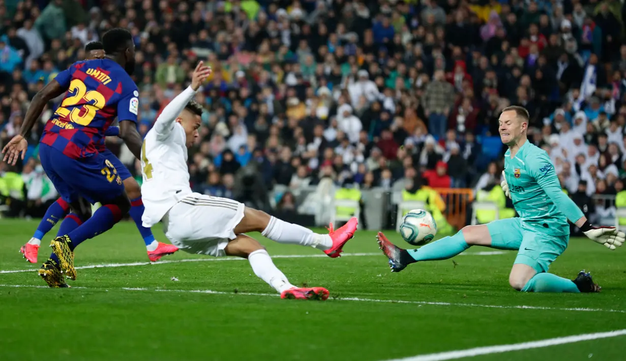 Penyerang Real Madrid, Mariano Diaz (tengah) mencetak gol melewati kiper Barcelona, Marc-Andre ter Stegen pada lanjutan pertandingan La Liga di Santiago Bernabeu, Minggu (2/3/2020).  Real Madrid membungkam Barcelona 2-0 dan merebut puncak klasemen dari Barcelona . (AP/Manu Fernandez)