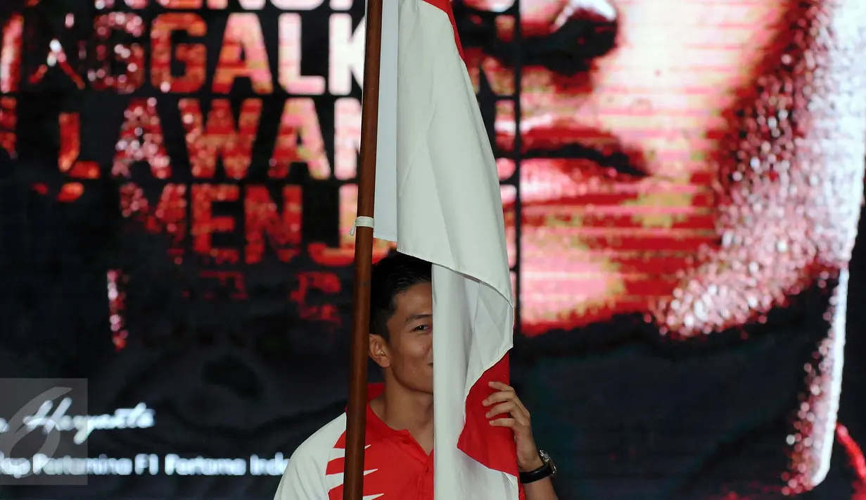 Rio Haryanto mencium bendera Merah Putih usai dipastikan bergabung dengan tim Manor Racing F1 di Jakarta, Kamis (18/2/2016). Rio bergabung dengan Manor Racing dan akan mengikuti balapan Formula 1 selama semusim penuh. (Liputan6.com/Helmi Fithriansyah)