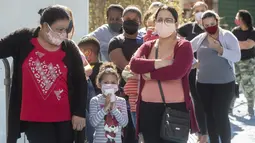 Sejumlah wanita dan anak-anak mengantre untuk menerima sumbangan pembalut wanita dan perlengkapan kebersihan lainnya di tengah pandemi COVID-19 di favela Paraisopolis, di Sao Paulo, Brasil (24/5/2021). Sumbangan ini disediakan oleh LSM lokal "G10 Favelas". (AP Photo/Andre Penner)