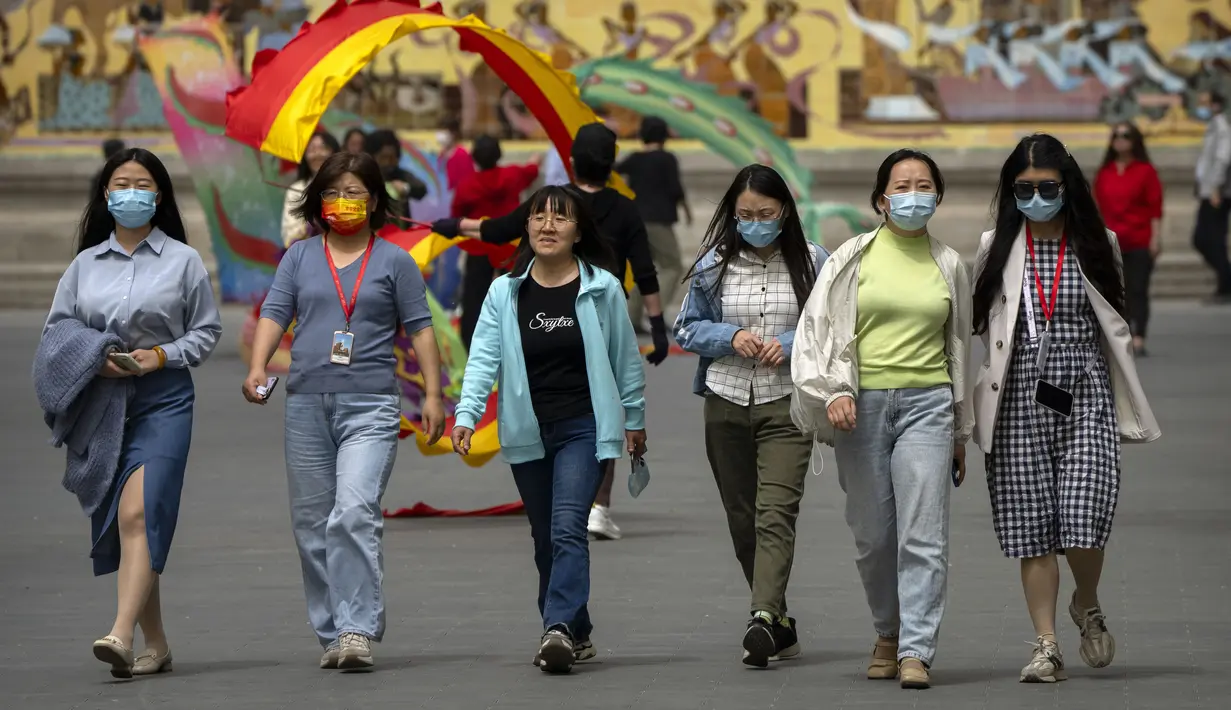 <p>Orang-orang yang memakai masker berjalan di taman umum di Beijing, Kamis (21/4/2022). Di daratan Cina, jumlah kematian meningkat menjadi lebih dari 20 dalam wabah di Shanghai yang menutup kota terbesar di negara itu. (AP Photo/Mark Schiefelbein)</p>