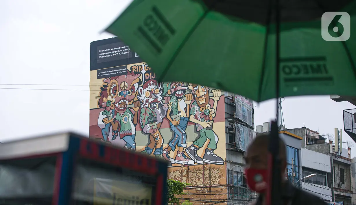 Seniman menyelesaikan pembuatan mural dalam acara Converse City Forest di Fatmawati, Jakarta, Sabtu (6/3/2021).  Mural digambar menggunakan cat khusus Grephenstone yang dapat menyerap polusi udara setara 177 pohon. (Liputan6.com/Faizal Fanani)
