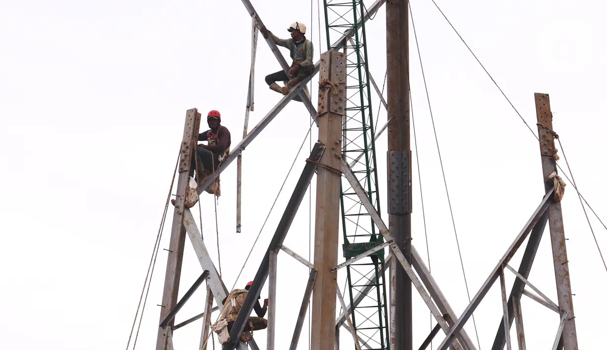 Pekerja tengah melakukan aktivitas kerja pada ketinggian di menara sutet di kawasan Karang Tengah, Kota Tangerang, Banten, Jumat (8/1/2021). Keselamatan dan kesehatan kerja (K3) merupakan hal yang mutlak bagi para pekerja di ketinggian dengan risiko tinggi. (Liputan6.com/Angga Yuniar)