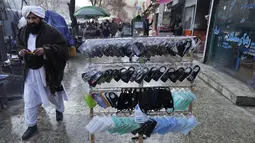 Masker untuk membantu mencegah penyebaran virus corona dijual di sebuah pasar, di Kabul, 7 Februari 2022. Lima dari 38 rumah sakit perawatan COVID yang pernah beroperasi di Afghanistan terpaksa ditutup karena kekurangan dokter, obat-obatan dan bahkan pemanas. (AP Photo/Hussein Malla)